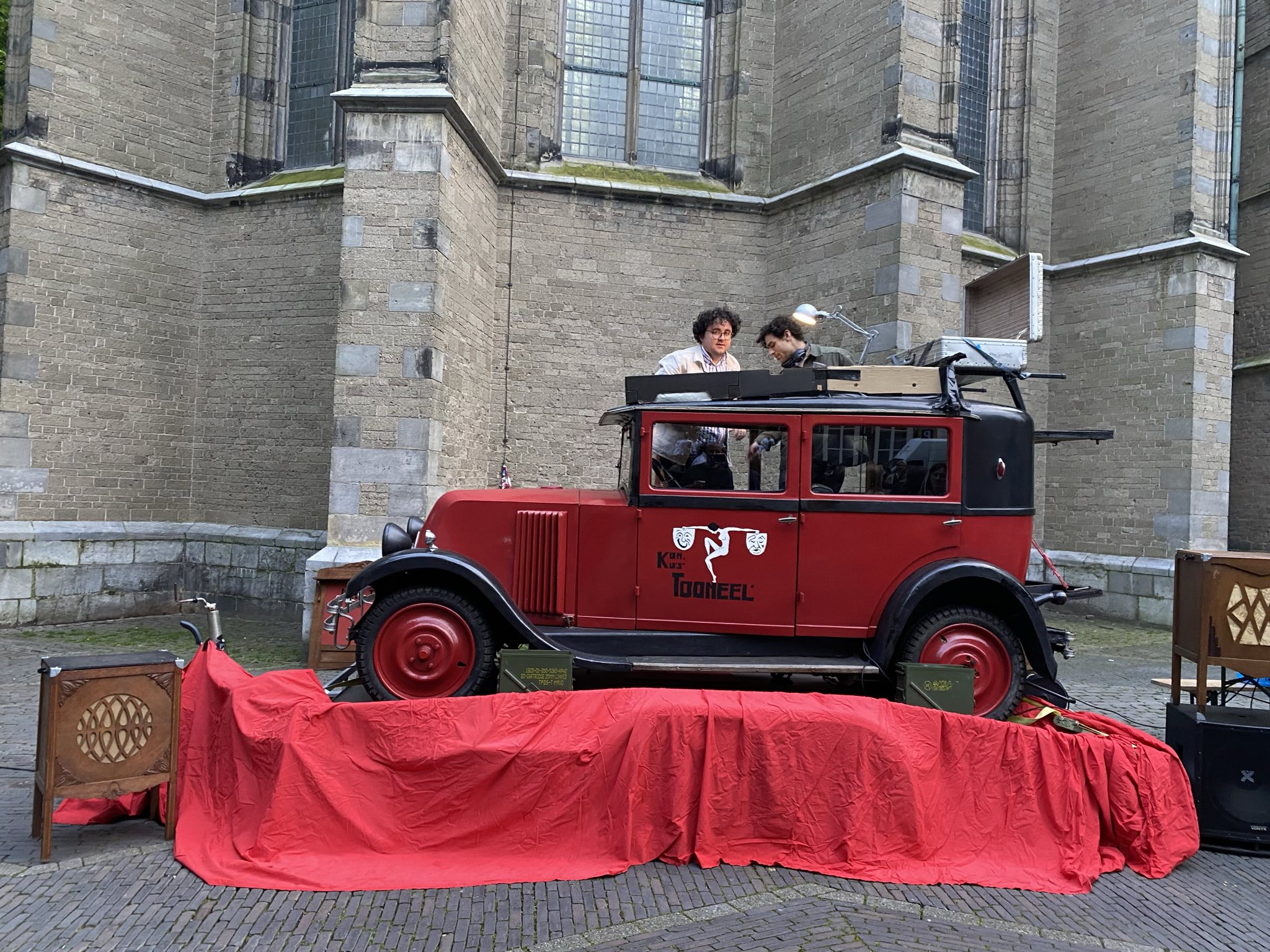 A DJ set being played out of the top of an old red car