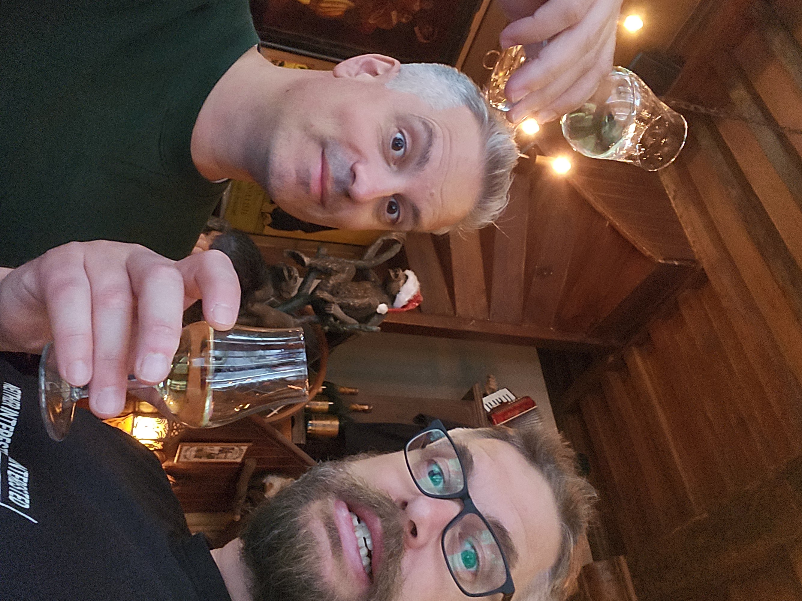 Mark and I enjoying a glass of Jenever, behind us is a statue of a monkey with a Christmas hat on, in June