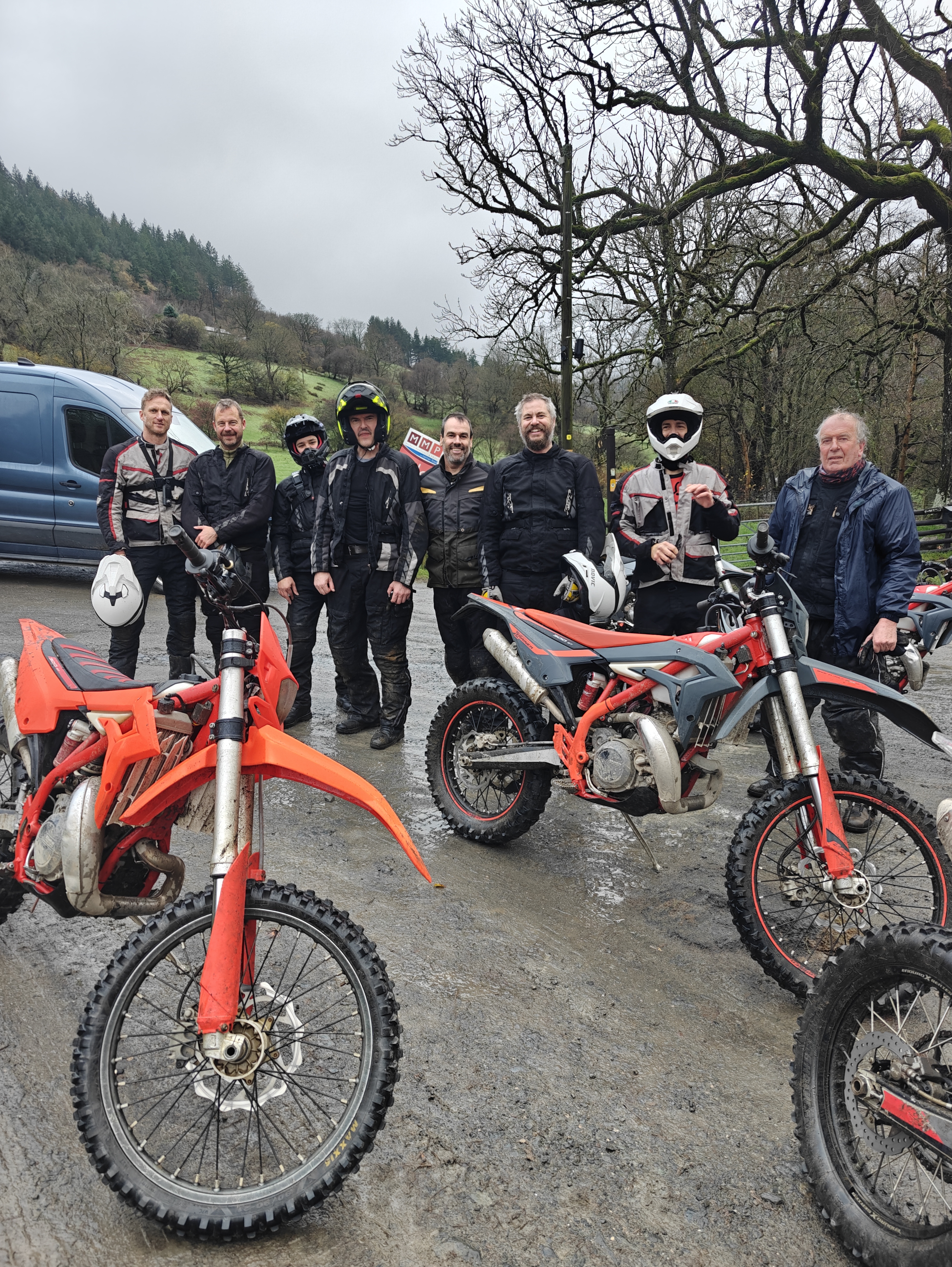 A bunch of middle age dudes grinning like idiots after hooning around on dirt bikes in the Welsh rain