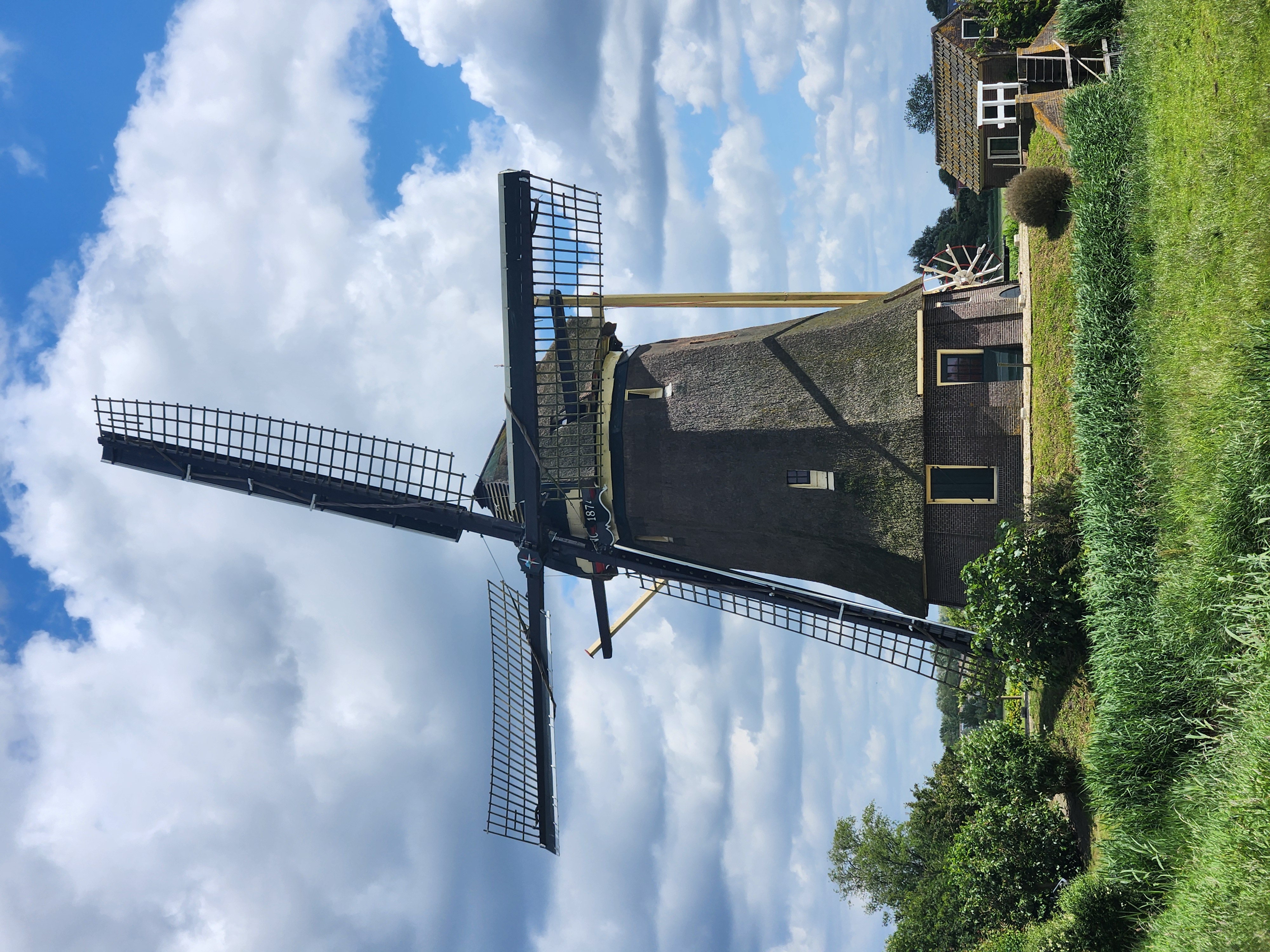 A windmill. The sails are furled, the sides are made of thatch
